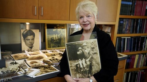 HOLD TO MOVE THURSDAY AUG 26 WITH STORY Diane Capone holds a copy of a photograph of her father, Albert Sonny Capone  as a young boy and her grandfather Al Capone on display at Witherells Auction House in Sacramento, Calif., Wednesday, Aug. 25, 2021. The granddaughter of the famous mob boss, she and her two surviving sisters will sell 174 family heirlooms at an Oct. 8 auction titled A Century of Notoriety: The Estate of Al Capone, that will be held by Witherells in Sacramento. (AP Photo/Rich Ped