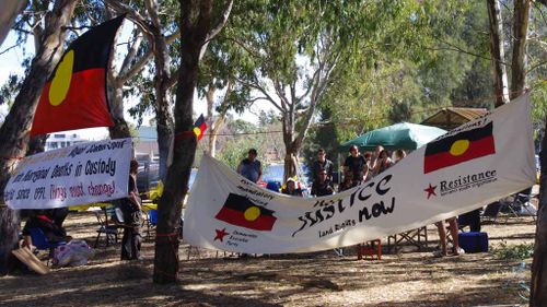 Aboriginal flags and protest banners at an Aboriginal “tent embassy” appear at Heirisson Island in Perth in 2012. (AAP) 