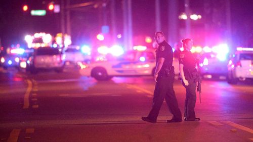 Police officers stand guard down the street. (AP)