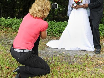 Female wedding photographer with couple