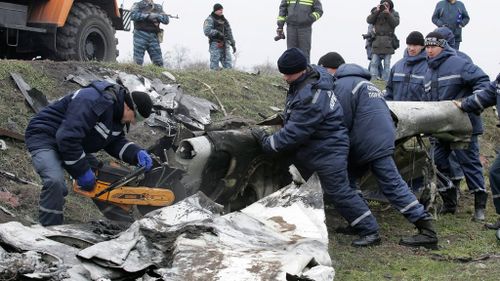 The crews cut pieces of the debris with metal saws at the crash site near the village of Grabove, Ukraine. (AAP)