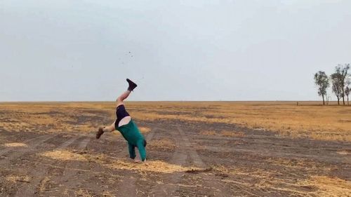 A farmer from Coonamble celebrates as the heavens open up.