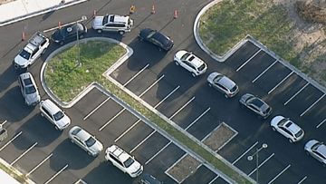 Cars snake around the car park as people wait to be tested in Keysborough in Victoria.