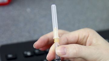 An investigation is under way after a woman was given a COVID-19 vaccination with a used needle. 