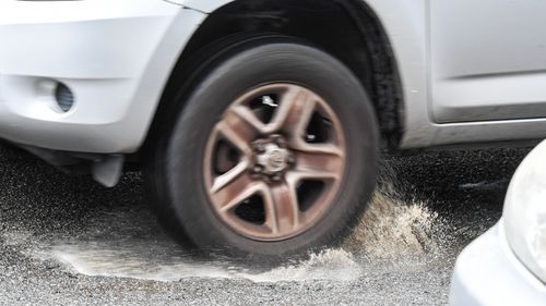 Cars swerve to miss a pothole in York Road, Queens Park, Sydney.