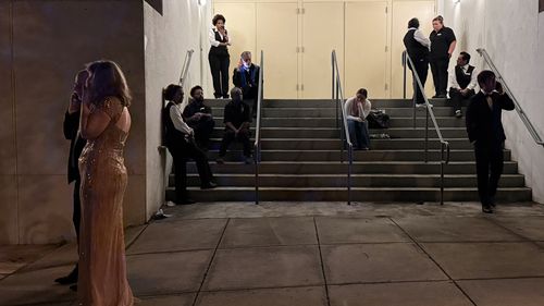 Attendees and hotel workers outside of the venue following the security incident.