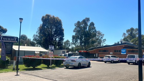 A caravan park in a rural NSW town has become a crime scene after a woman's body was found and a man was arrested.