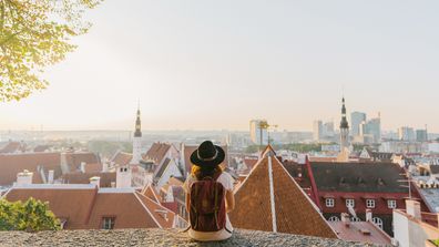 Young Caucasian woman sitting and looking at Tallinn in the morning