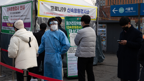 Members of the public wait in line at a temporary COVID-19 testing station set up outside Seoul Station on March 4.