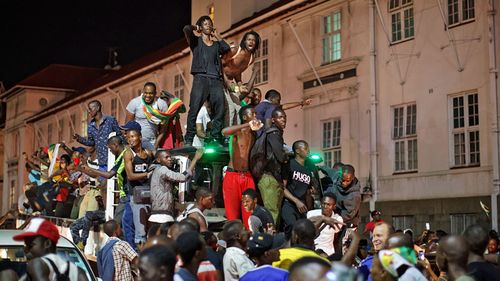 Celebrations marking the end of Robert Mugabe's 37-year rule lasted long into the night in Harare. (Photo: AP).