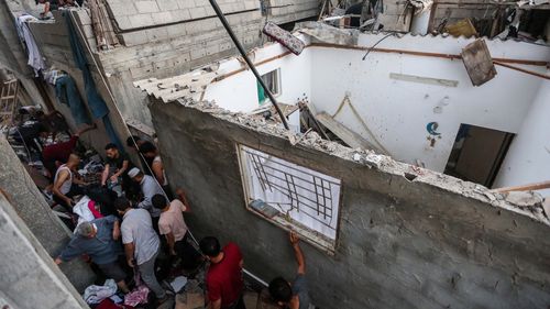 People search through buildings that were destroyed during Israeli air raids