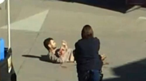 The armed man lying on the ground after being shot.