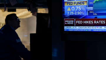 A screen displays the news of the Federal Reserve&#x27;s rate change as traders work and watch at the New York Stock Exchange in New York, Wednesday, July 27, 2022. Stocks on Wall Street are solidly higher in afternoon trading Wednesday after the Federal Reserve raised its key interest rate.