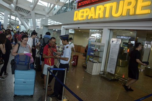 Tourists go through the departure gate at Bali international airport. (AAP)