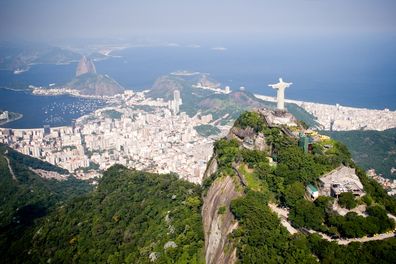 Aerial view of Rio de Janeiro on a sunny day taken from a helicopter.  In view are the landmarks Christ the Redeemer and Sugarloaf Mountain.