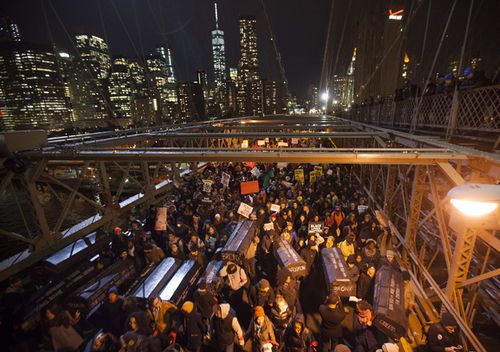 A group of protesters rallying against a grand jury's decision not to indict the police officer involved in the death of Eric Garner occupies the eastbound traffic lanes of the Brooklyn Bridge in the early morning hours of December 4, 2014.