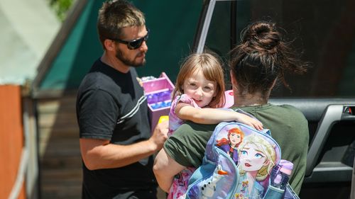 Cleo Smith is carried inside a friend's house by her mother in Carnarvon.