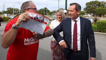 West Australian Premier Mark McGowan and his wife Sarah McGowan bump elbows with a campaigning volunteer.