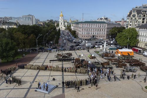In this photo provided by the Ukrainian Presidential Press Office, Ukrainian President Volodymyr Zelenskyy, bottom centre left, walks to speak during an event for marking Statehood Day in Mykhailivska Square, with destroyed Russian tanks on display in the background, in Kyiv, Friday, July 28, 2023. 