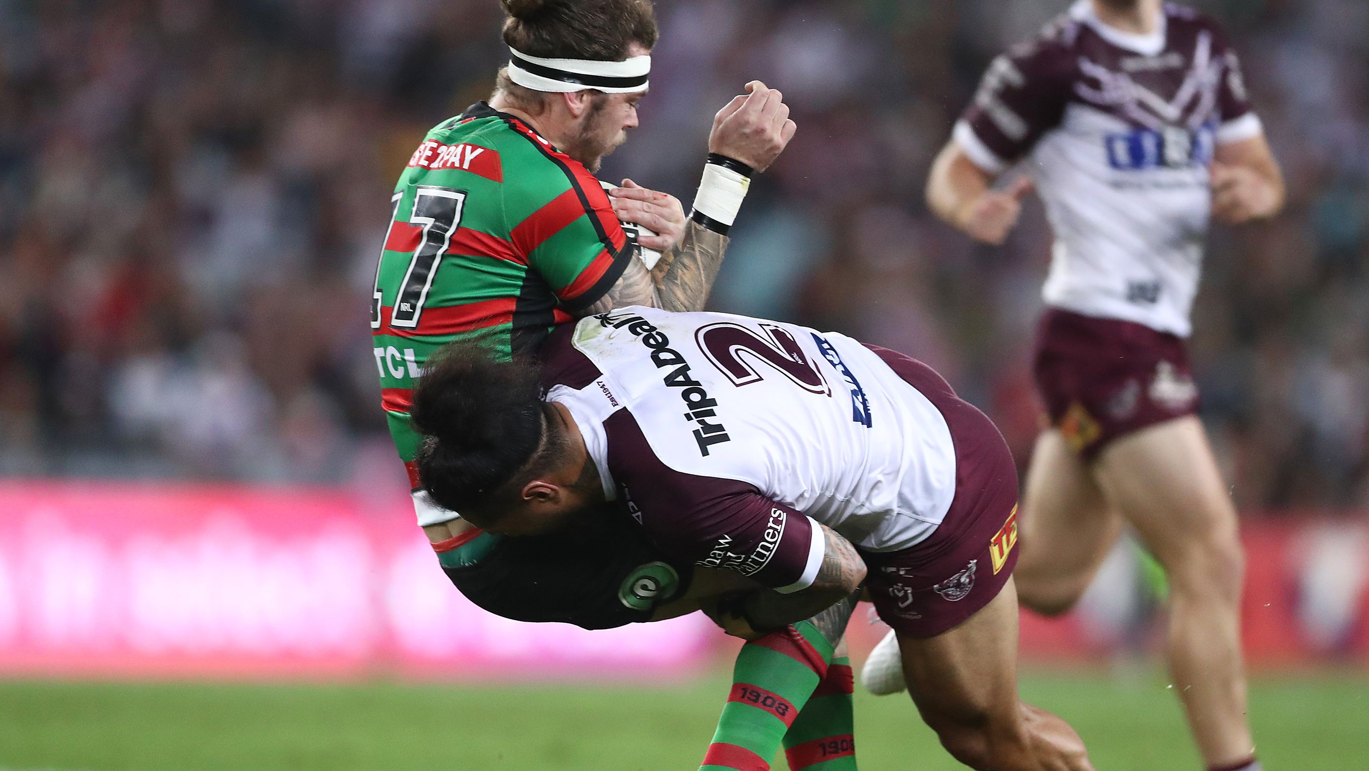 Jorge Taufua of the Sea Eagles tackles Ethan Lowe of the Rabbitohs.