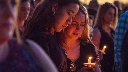 Hundreds of community members take part in a candlelight vigil at the Amphitheater at Pine Trails Park, Parkland, Florida. (AAP)
