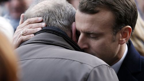 French President Emmanuel Macron embraces a grieving relative of the Bataclan terror attack.