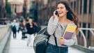 Smiling student walking and talking on the phone