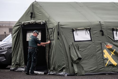 Un membro della Guardia Civil termina di montare una tenda in un punto di accoglienza previsto per i passeggeri della MV Hondius al porto di Granadilla.