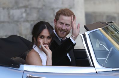 FILE - In this Saturday, May 19, 2018 file photo the newly married Duke and Duchess of Sussex, Meghan Markle and Prince Harry, leave Windsor Castle in a convertible car after their wedding in Windsor, England, to attend an evening reception at Frogmore House, hosted by the Prince of Wales. Prince Harry and Meghan Markle are to no longer use their HRH titles and will repay £2.4 million of taxpayer's money spent on renovating their Berkshire home, Buckingham Palace announced Saturday, Jan. 18. 202