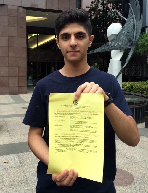 Pouya outside the US Consulate in Melbourne with the document given to him declining his visa. (AAP)