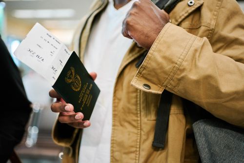 Primo piano di un viaggiatore maschio in vacanza con in mano il passaporto e la carta d'imbarco all'aeroporto