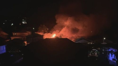 A wall of flame rose over the Brisbane suburb of Clayfield after a housefire broke out.