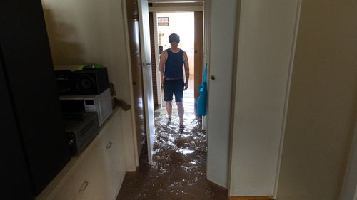 section locale de Shepparton "John" traverser sa maison inondée.
