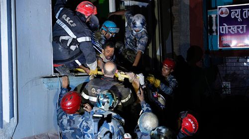 Rishi Khanal is rescued after four days trapped inside a collapsed apartment complex. (AAP)