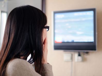 Woman watching the news on TV.