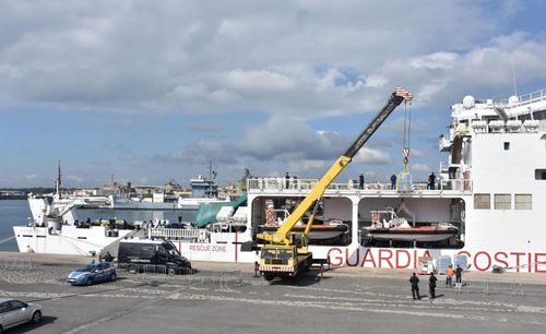 Water and other supplies are being loaded on the Italian Coast Guard ship Diciotti, where migrants waited permission to disembark, in the port of Catania, Italy