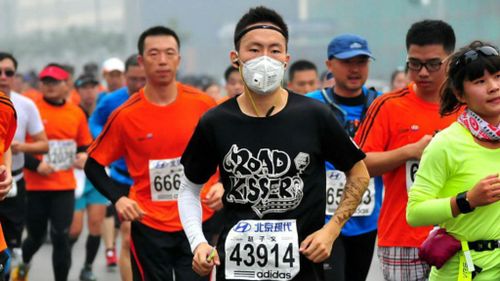 Runners wear masks as smog hits Beijing Marathon