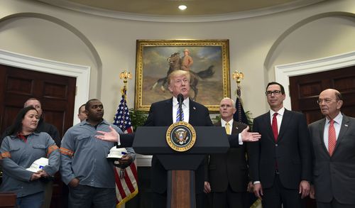 President Donald Trump, center, speaks in the Roosevelt Room of the White House in Washington today. (AAP)