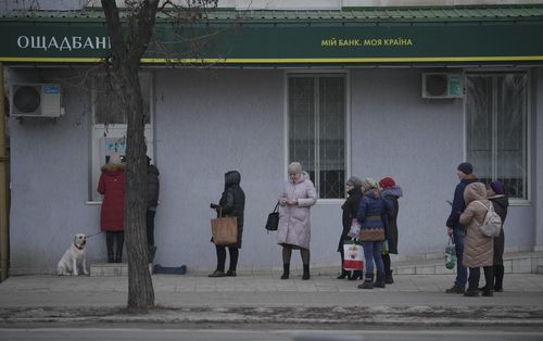 People queue to use an ATM machine outside in Sievierodonetsk, the Luhansk region, eastern Ukraine, Thursday, Feb. 24, 2022. 