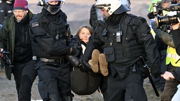 Police officers carry Swedish climate activist Greta Thunberg away from the edge of the Garzweiler II opencast lignite mine during a protest action by climate activists after the clearance of Luetzerath, Germany, Tuesday, Jan. 17, 2023.  