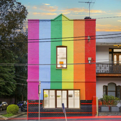 Exterior of home features the pride flag and a Freddie Mercury mural