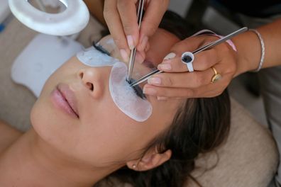Stock image of woman having eyelash extensions applied