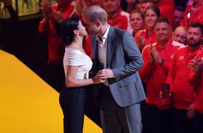 Prince Harry and Meghan Markle share a kiss on stage at the 2022 Invictus Games