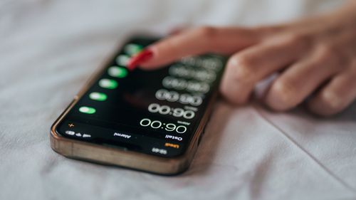Uma jovem coloca um alarme no telefone pela manhã