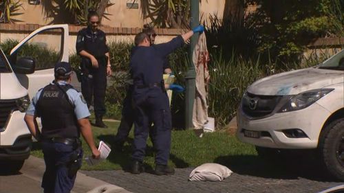 Police officers establish a crime scene at the Sydney property.