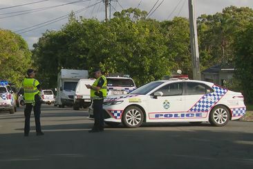 A man is fighting for his life while another is in custody after an alleged stabbing near a Brisbane school. 