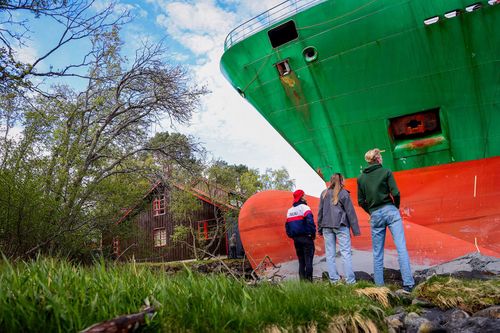 Bystanders look at the grounded ship.