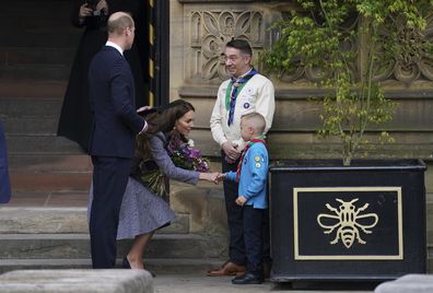 Prince William and his wife Kate, Duchess of Cambridge speak to Archie McWilliams, aged 7, from the First Longford Scout Group in Stretford, and his uncle Greater Manchester West Scouts' County Commissioner Andy Farrell, as they leave after attending the launch of the Glade of Light Memorial, outside Manchester Cathedral, which commemorates the victims of a suicide bomb attack at a 2017 Ariana Grande concert, in Manchester, England, Tuesday, May 10, 2022. 