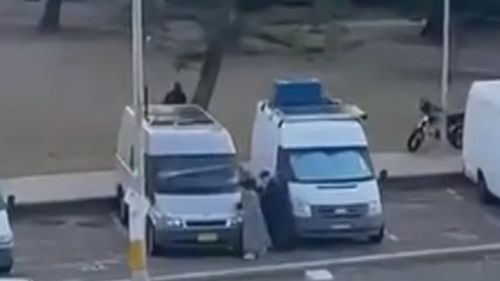 An elderly couple ducks behind vans to hide just metres away from one of the alleged gunmen of the Bondi Beach terrorist attack. 