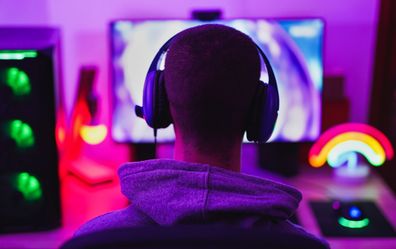 Young man wearing headset and play computer video games online - Home isolated for coronavirus outbreak